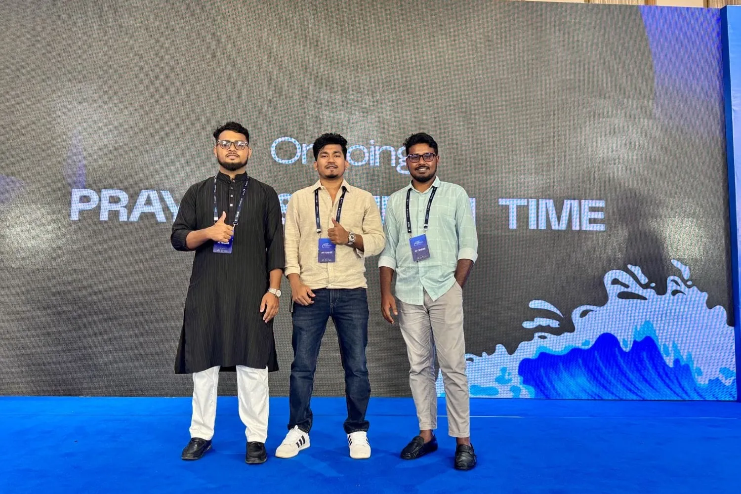Shakawat Hridoy with two other attendees on the main stage at BITPA Conference 2026 in Cox's Bazar, all wearing attendee badges
