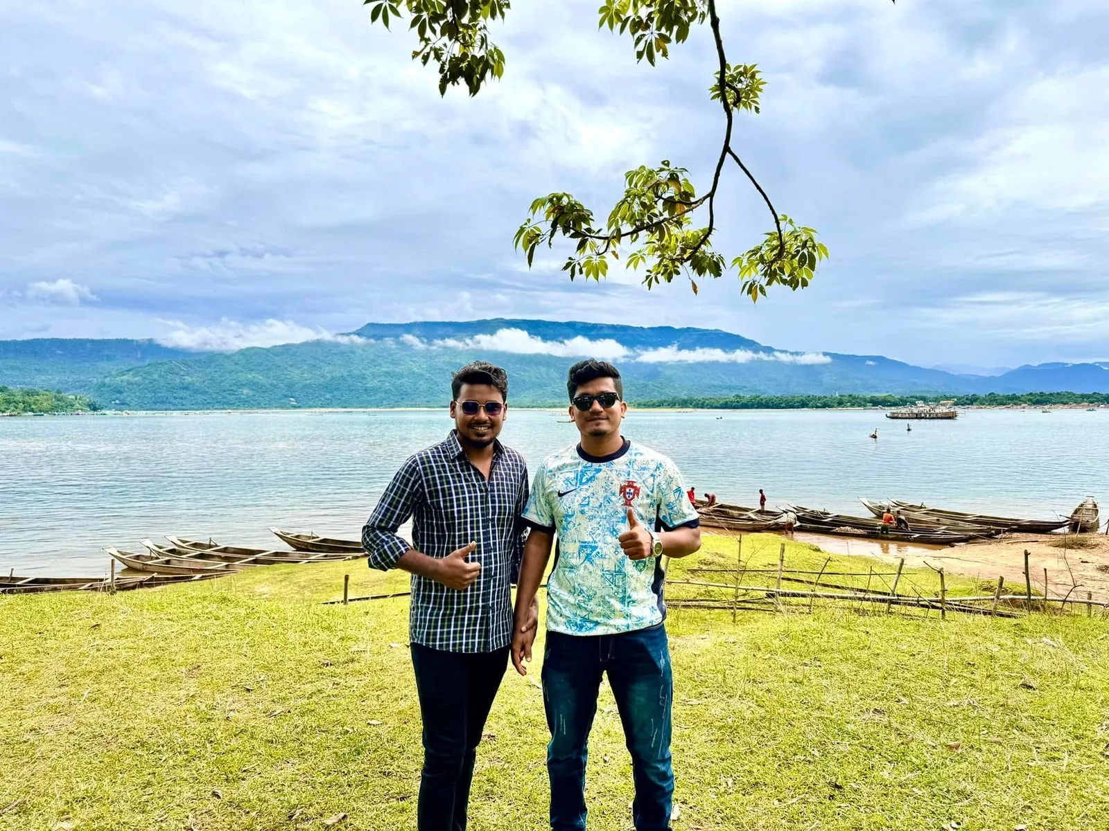 Sitting by the lake with friends, hills in the background, at Tanguar Haor