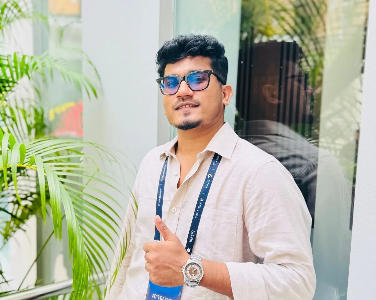 Shakawat Hridoy in a linen shirt and sunglasses giving a thumbs up, wearing an attendee lanyard at BITPA Conference 2026