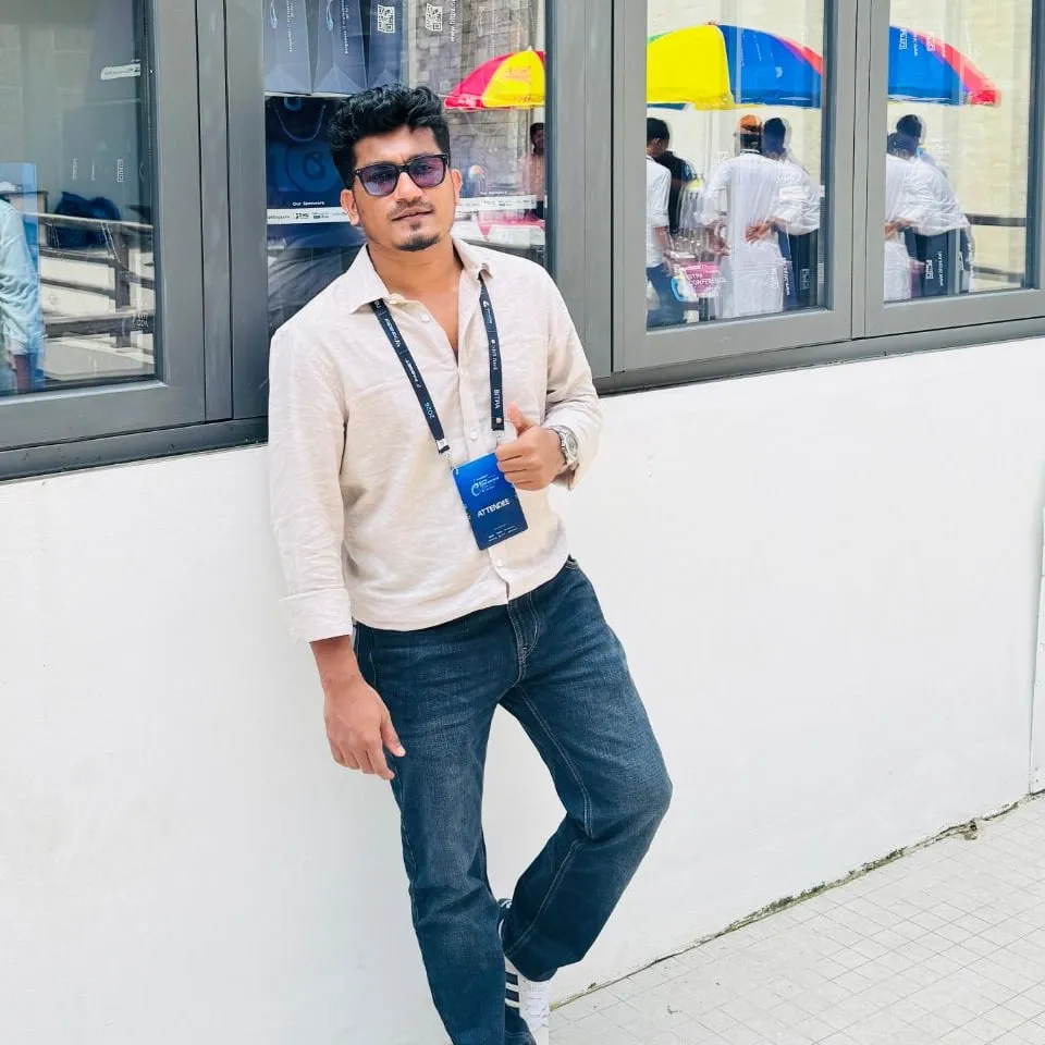 Shakawat Hridoy leaning against the glass front of the BITPA Conference 2026 venue, attendee lanyard on