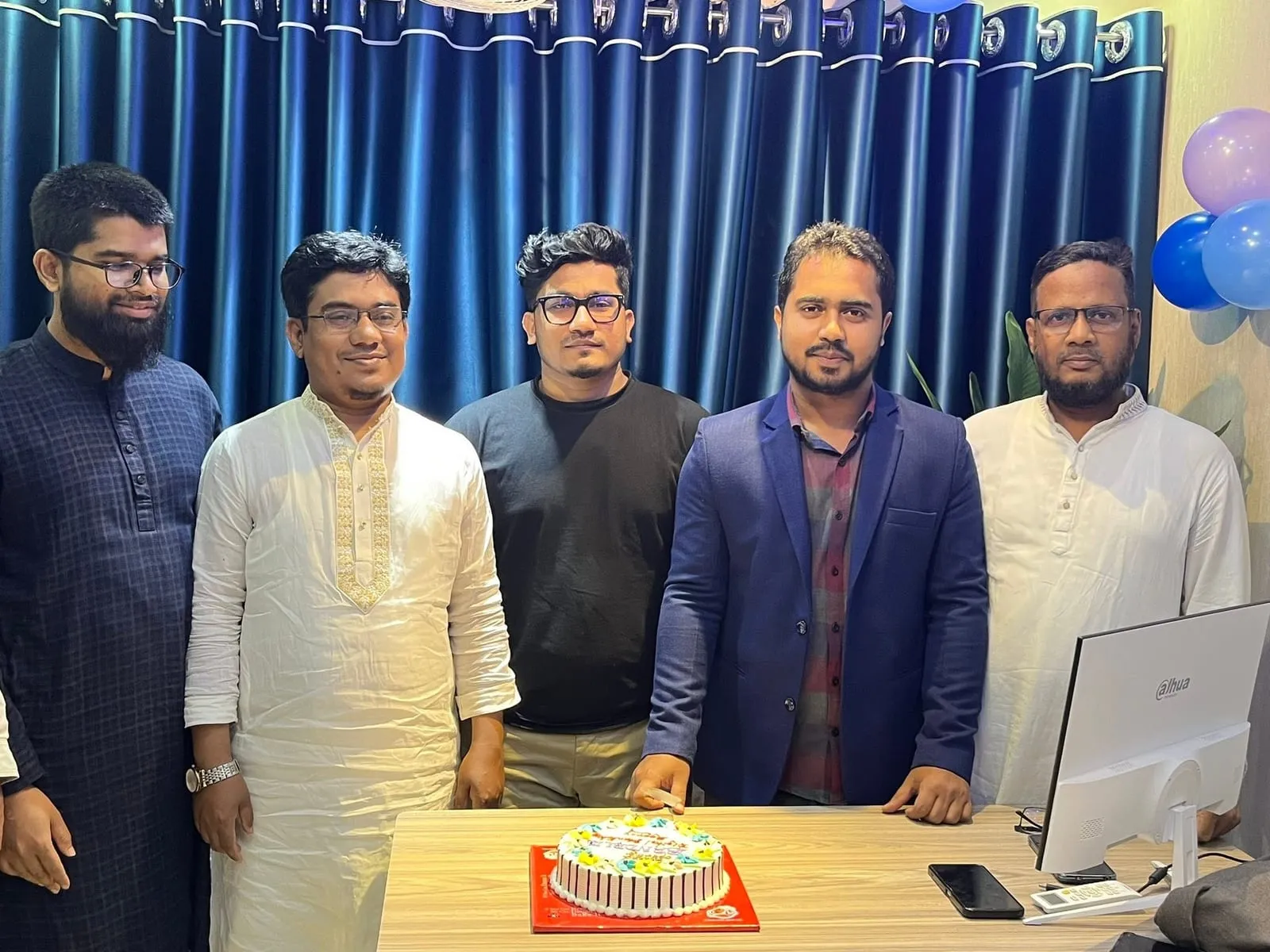 Shakawat Hridoy with a group of people around a cake at the TrueHive Digital office in Feni