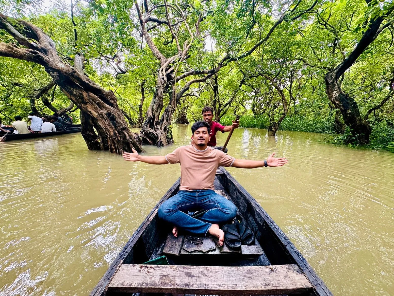 A wooden boat on the turquoise water of a lake in the Tanguar Haor region of Sunamganj, Bangladesh, with hills behind